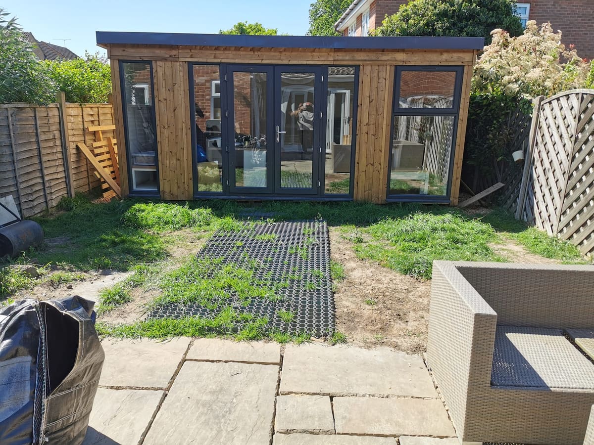Before: Grass matting in front of a garden room to artificial grass