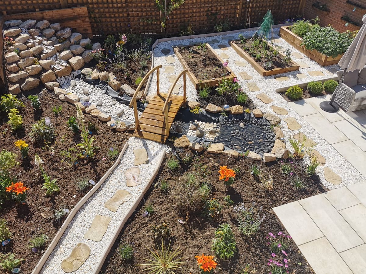After: New-build lawn to a landscaped garden with a pebble stream, raised beds and paving